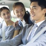 Young couple with daughter riding in car together